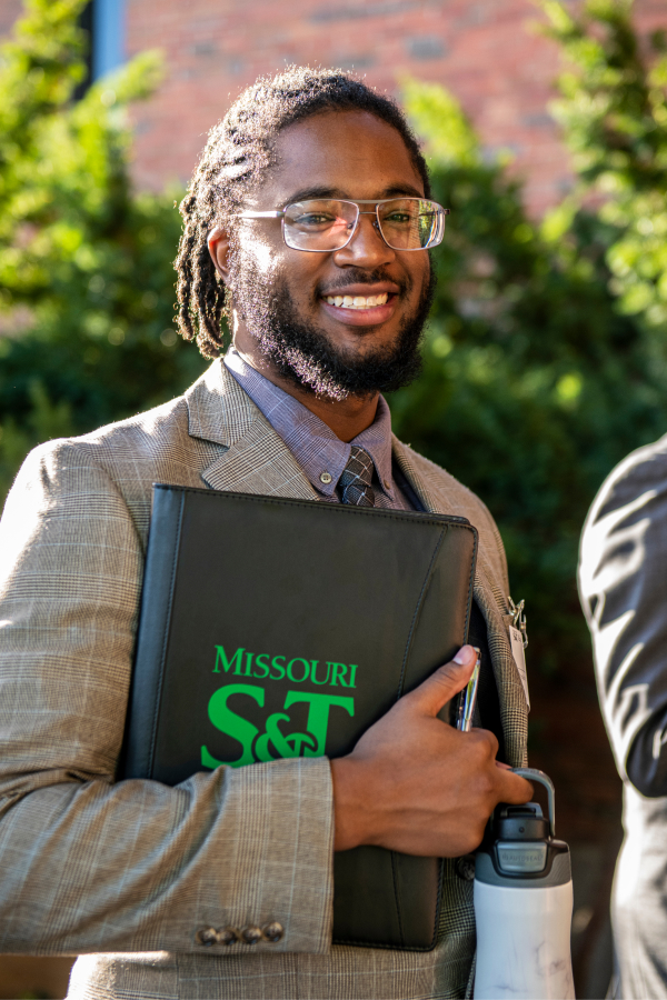 Student smiling holding resume folder